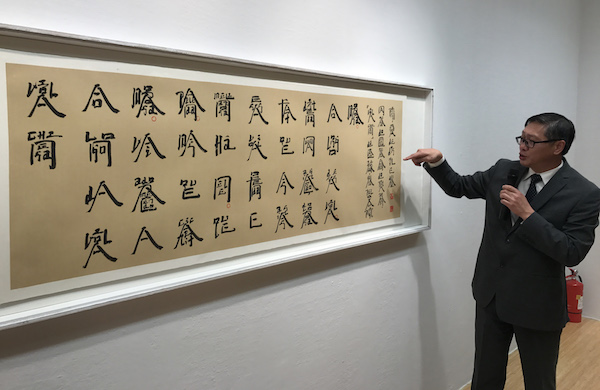 展覽現場，澳門藝術博物館館長陳繼春介紹徐冰的萄文書法作品